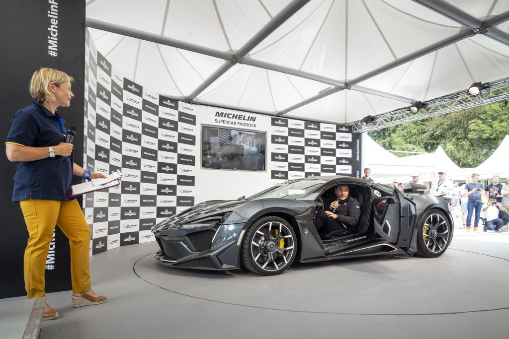 Vicki Butler-Henderson presenterar W Motors Fenyr SuperSport på Goodwood Festival of Speed 2018. I bilen sitter W Motors grundare Ralph R. Debbas.